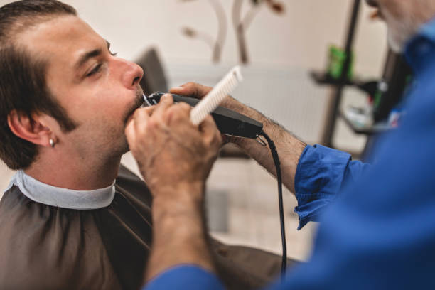 istock Man getting his beard trimmed with electric razor 996129384