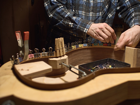 Glue lining to the side of the guitar. The process of making a classical guitar.