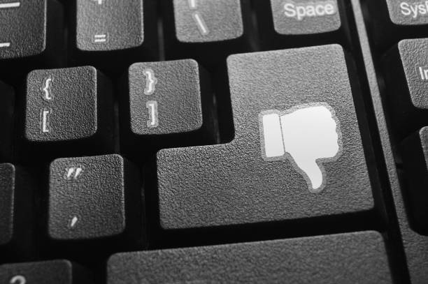 Thumb down or dislike button on keyboard. Thumb down or dislike button on keyboard. cyberbullying stock pictures, royalty-free photos & images