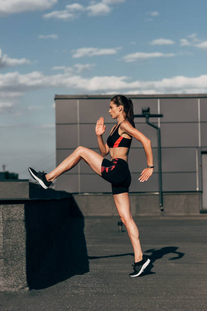 istock athletic girl in sportswear doing cardio training on roof 996136520
