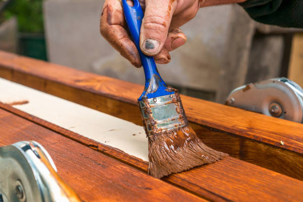 istock Painter with paintbrush painting wooden surface 996160074