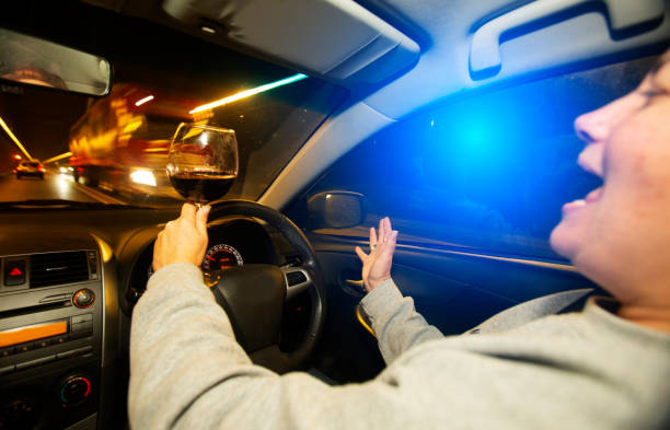 Drinking and driving at night holding a glass of red wine Drinking and driving at night holding a glass of red wine drunk visual stock pictures, royalty-free photos & images