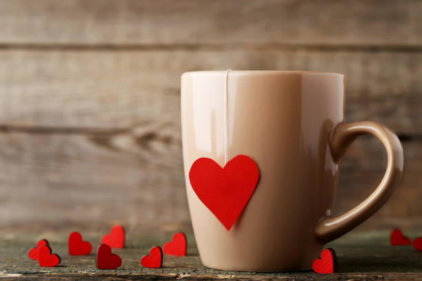 istock Cup of tea with red hearts on wooden table 996160818
