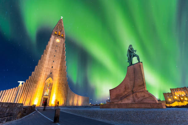 aurora boreal sobre la iglesia de hallgrímskirkja en el centro de la ciudad de reykjavik en islandia - islandia fotografías e imágenes de stock
