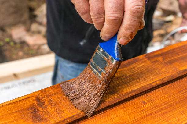istock Painter with paintbrush painting wooden surface 996162084