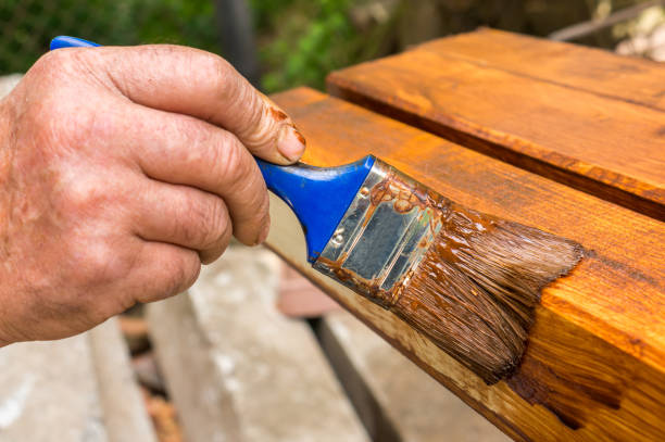 istock Painter with paintbrush painting wooden surface 996165786