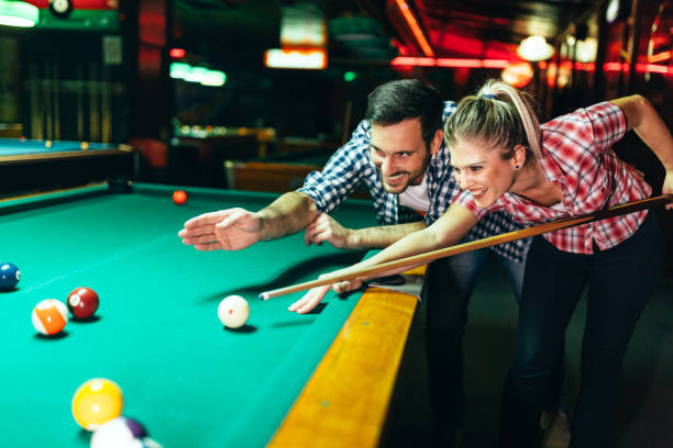 istock Young couple playing snooker together in bar 996166532