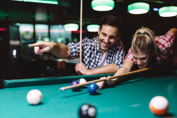 istock Young couple playing snooker together in bar 996166632