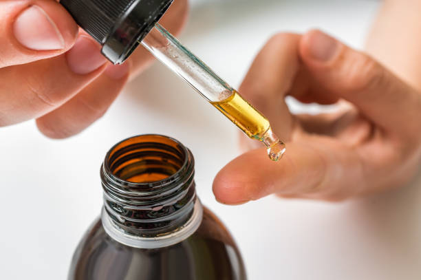Collagen serum for face is dropping on female finger