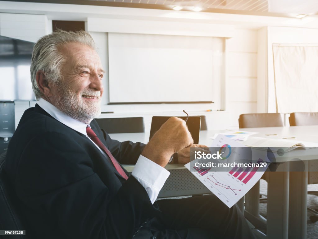 Senior businessman feeling happy and smiling in modern office room CEO Stock Photo