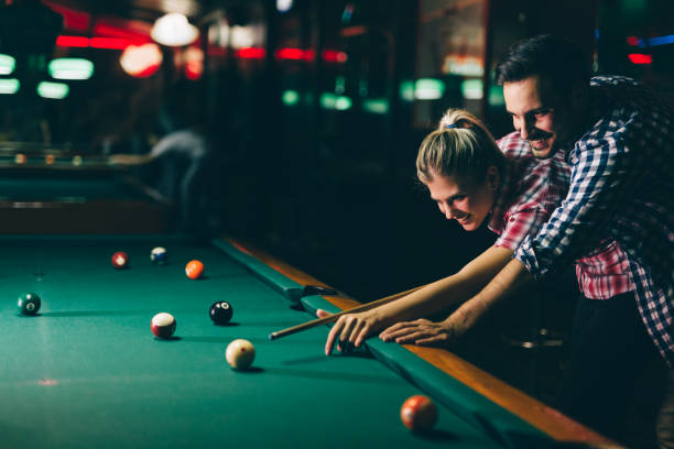 istock Young couple playing snooker together in bar 996167252