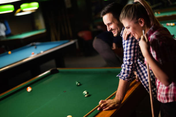 istock Young couple playing snooker together in bar 996167508