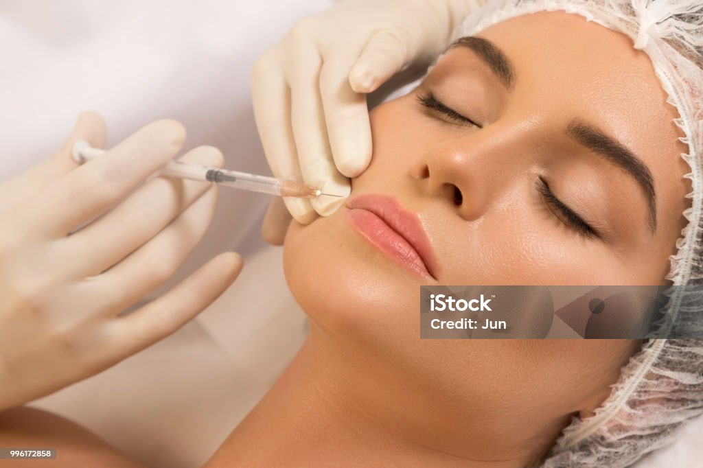 Llips augmentation procedure Woman during lips augmentation procedure. Human Lips Stock Photo