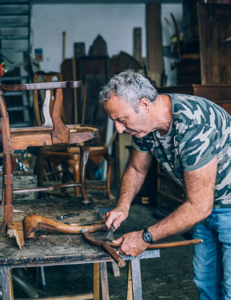 istock Carpenter restoring an old wooden chair 996176464