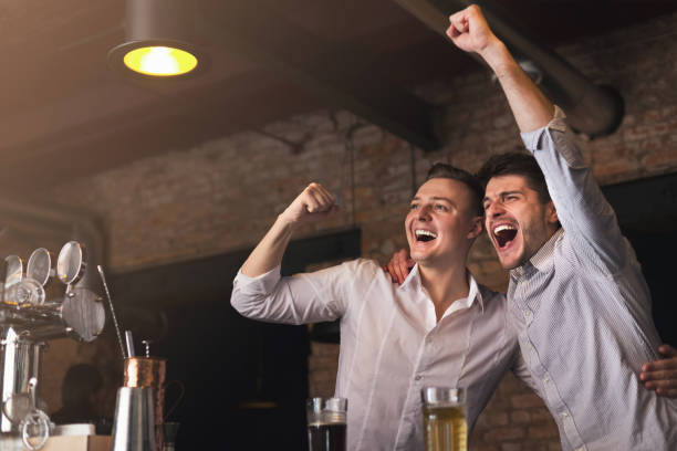 istock Happy friends cheering for favorite team in pub 996178228