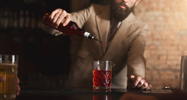 istock Bartender pouring red liquor to measuring glass 996178306