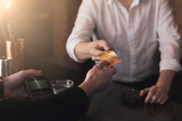 istock Man giving credit card to bartender in pub 996178440