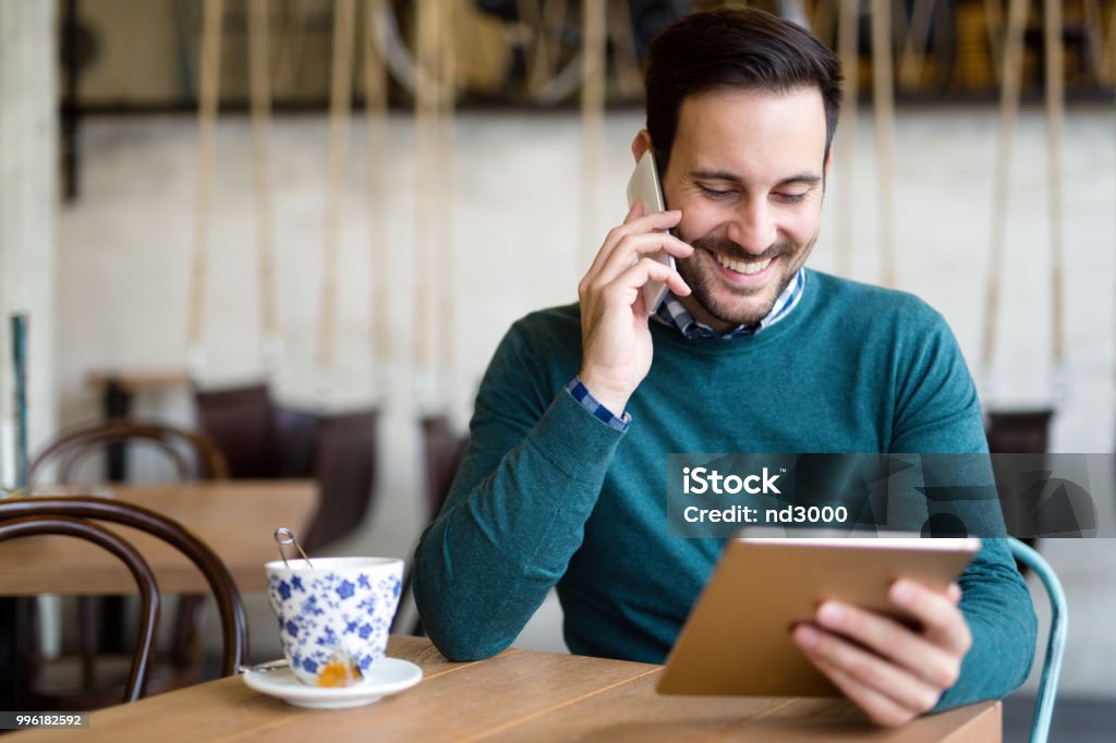 Portrait of busy businessman in coffee shop Portrait of busy businessman in coffee shop talking on phone Adult Stock Photo
