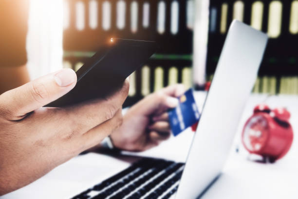 istock Online payment,Man's hands holding smartphone and using credit card for online shopping. 996184100