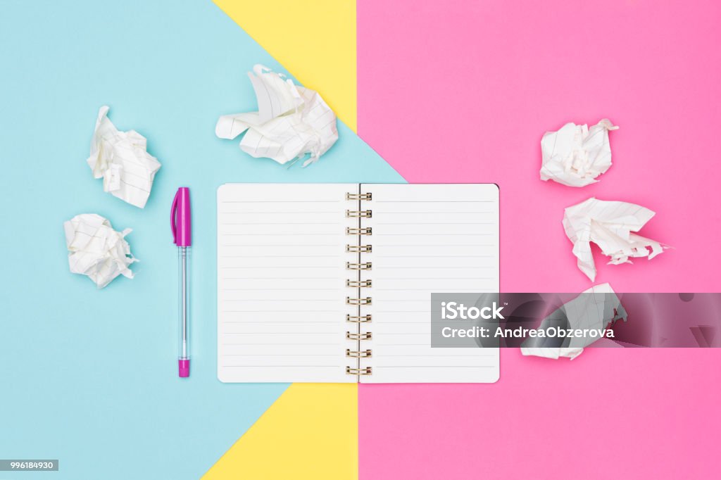 Writer's block. Ideas, brainstorming, creativity, imagination, deadline, frustration concept. Top view photo of office desk with blank mock up open notepad and crumpled paper on pastel background. Letter - Document Stock Photo