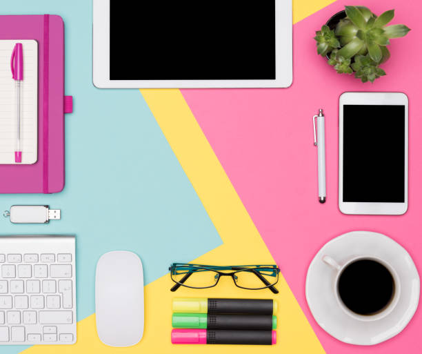 istock Office Desk Working Space Flat Lay. Top view photo of workspace with blank mock up tablet and smartphone, coffee cup, keyboard, notepad and succulent plant on multicolored pastel background. 996187770