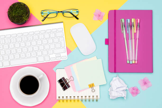 istock Office Desk Working Space Flat Lay. Top view photo of workspace with keyboard, notepad, coffee cup and glasses on pastel background. Pastel pink, yellow and blue color working desk concept. 996187922