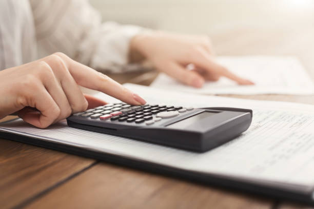 istock Woman hands with calculator and papers 996190032