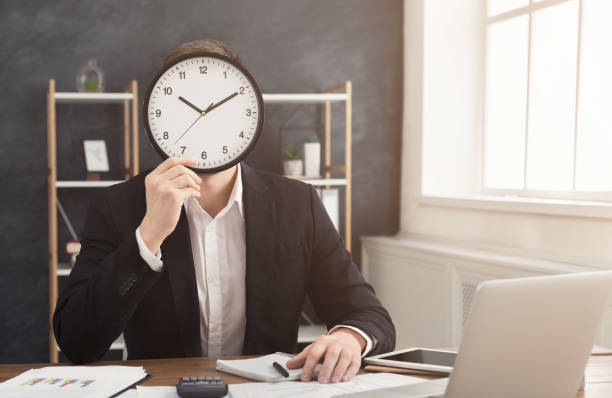 istock Man with big clock covering his face 996190804