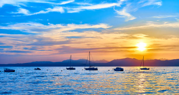 バ��ルドリーノの都市で美しい光の壮大な夕日 - lake garda sunset blue nautical vessel ストックフォトと画像