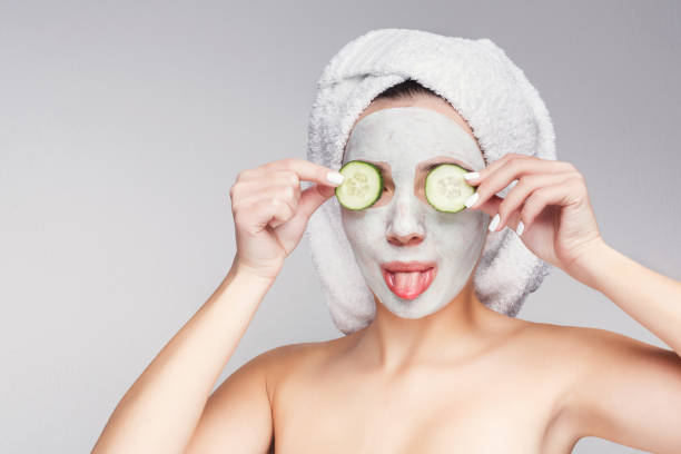 istock Beautiful girl with applied clay mask at grey background 996196254
