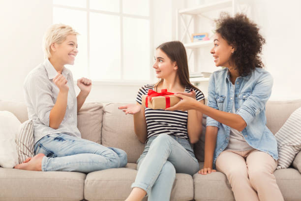 istock Excited woman getting gift from her friends 996198584
