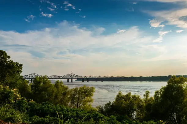 View of the Mississippi River with the Vicksburg Bridge on the background at sunset; Concept for travel in the USA and visit Mississippi