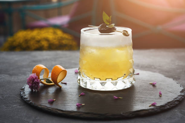 Yellow cocktail with citron on wooden background