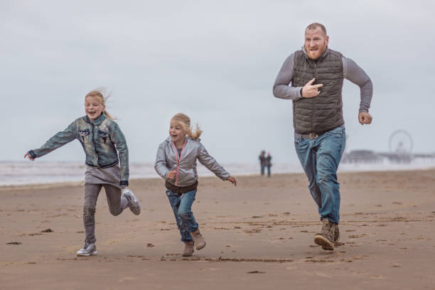 istock Single father and his daughters playing family games on a winter beach 996202002