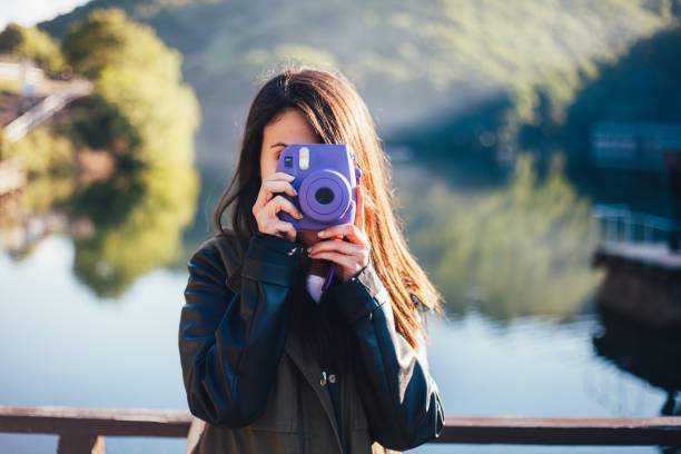 istock Woman with instant camera outside 996205438