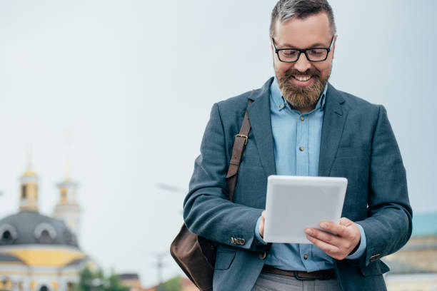istock beard businessman in eyeglasses using digital tablet in city 996207264