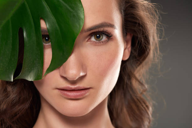 istock attractive pure girl with monstera leaf, isolated on grey 996220364