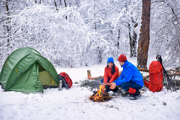 zimowy kemping w lesie z namiotem i ogniem. - transportation mountain winter couple zdjęcia i obrazy z banku zdjęć
