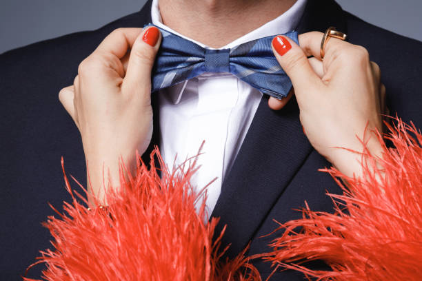 woman is helping to fit up a bow tie to her man - passion women human hand macro imagens e fotografias de stock