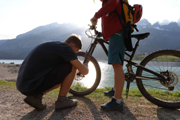 istock Young man fixes tire on mountain bike, Molveno, Sud Tyrol 996229882