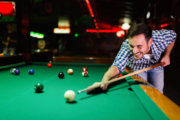 istock Young attractive man playing pool in bar 996230600