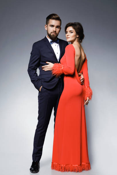 Mujer En Vestido Rojo Hermoso Y Hombre Clásico Traje Azul Con Corbata De Moño Foto de stock y más banco de imágenes de Parejas - iStock Mujer En Vestido Rojo Hermoso Y Hombre Clásico Traje Azul Con Corbata De Moño Foto de stock y más banco de imágenes de Parejas - iStock