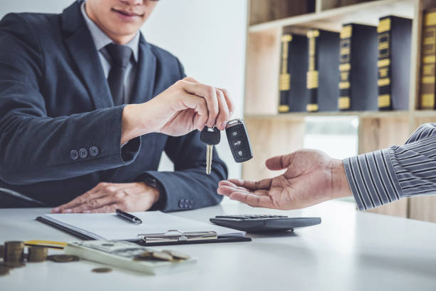 Salesman send key to customer after good deal agreement, successful car loan contract buying or selling new vehicle stock photo