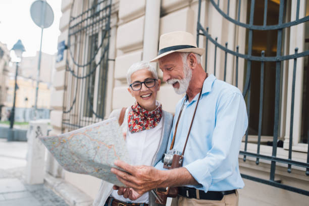 istock Smiling elderly tourists reading the map together 996237448