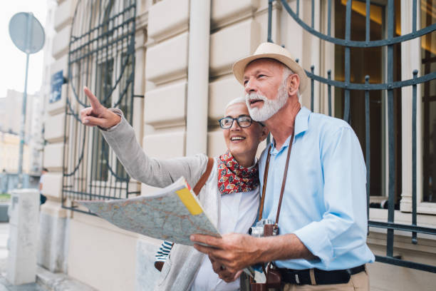 istock Senior man with the map looking at the direction his wife is pointing at 996237456