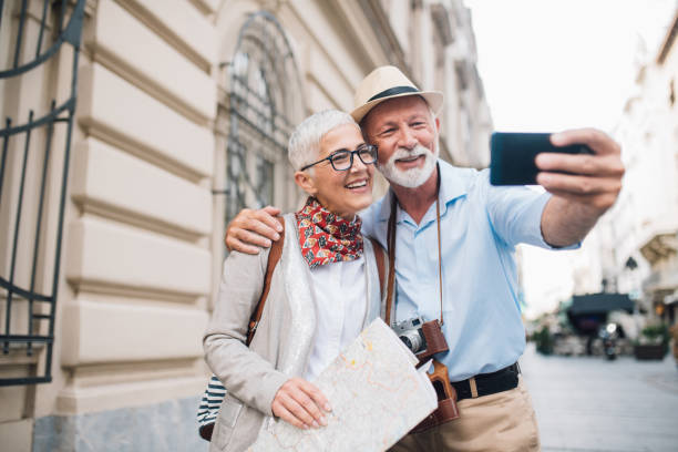 istock Happy couple with a map taking a selfie together 996237550