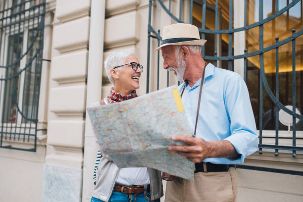 istock Elderly couple holding the map while looking at each other and smiling 996237562