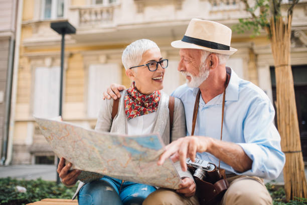 istock Elderly couple hugging and looking at the map together 996237684