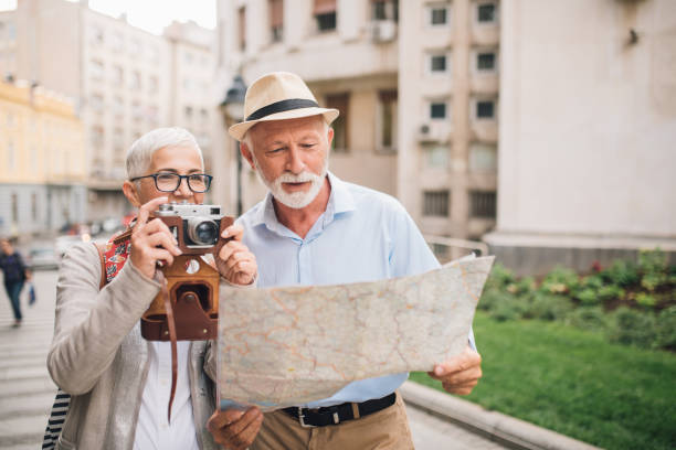 istock Senior couple with the map and camera in their hands 996238174