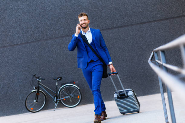 istock Handsome young man on business trip walking with his luggage. 996238208